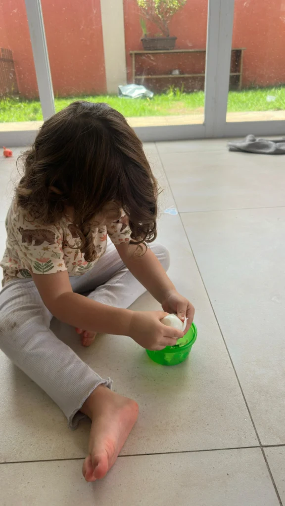 Criança brincando no chão de forma autônoma