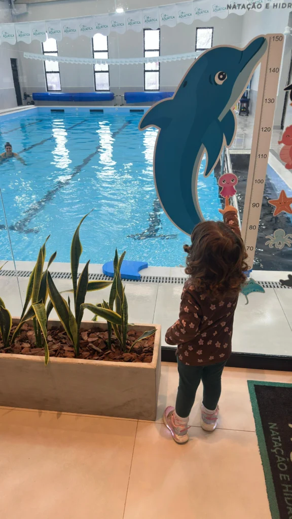 Criança na natação, ao lado da piscina
